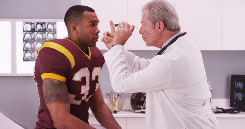 Doctor checking out football player